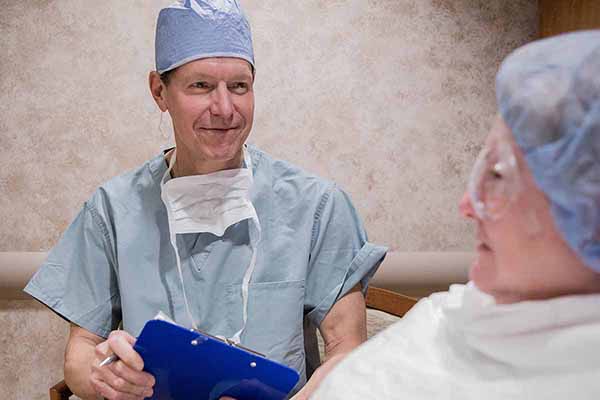 Doctor and patient sitting together reviewing and preparing for medical procedure.